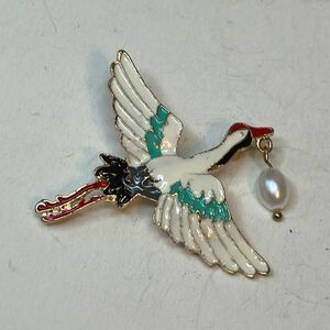 Gold tone white enamel stork carrying faux pearl pin brooch statement piece